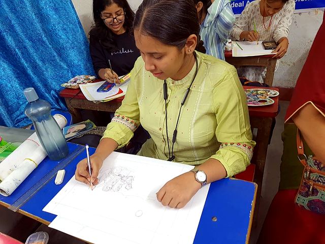 A student sketching carefully on paper in class