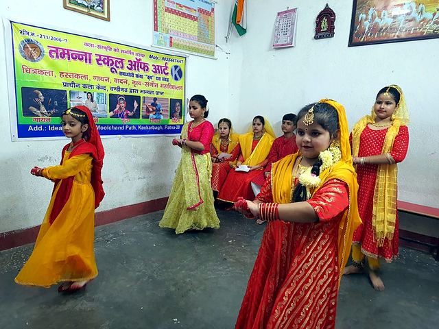 Girls in red and yellow dresses performing a folk dance on stage