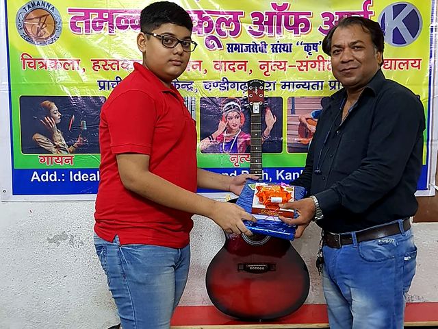 Volunteer handing over art material to children